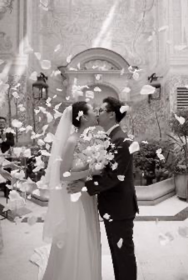 The newlyweds kiss under a shower of petals in the private patio, Hôtel Castille, Paris