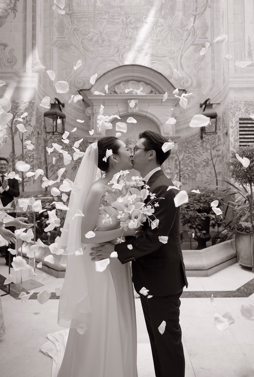 The newlyweds kiss under a shower of petals in the private patio, Hôtel Castille, Paris
