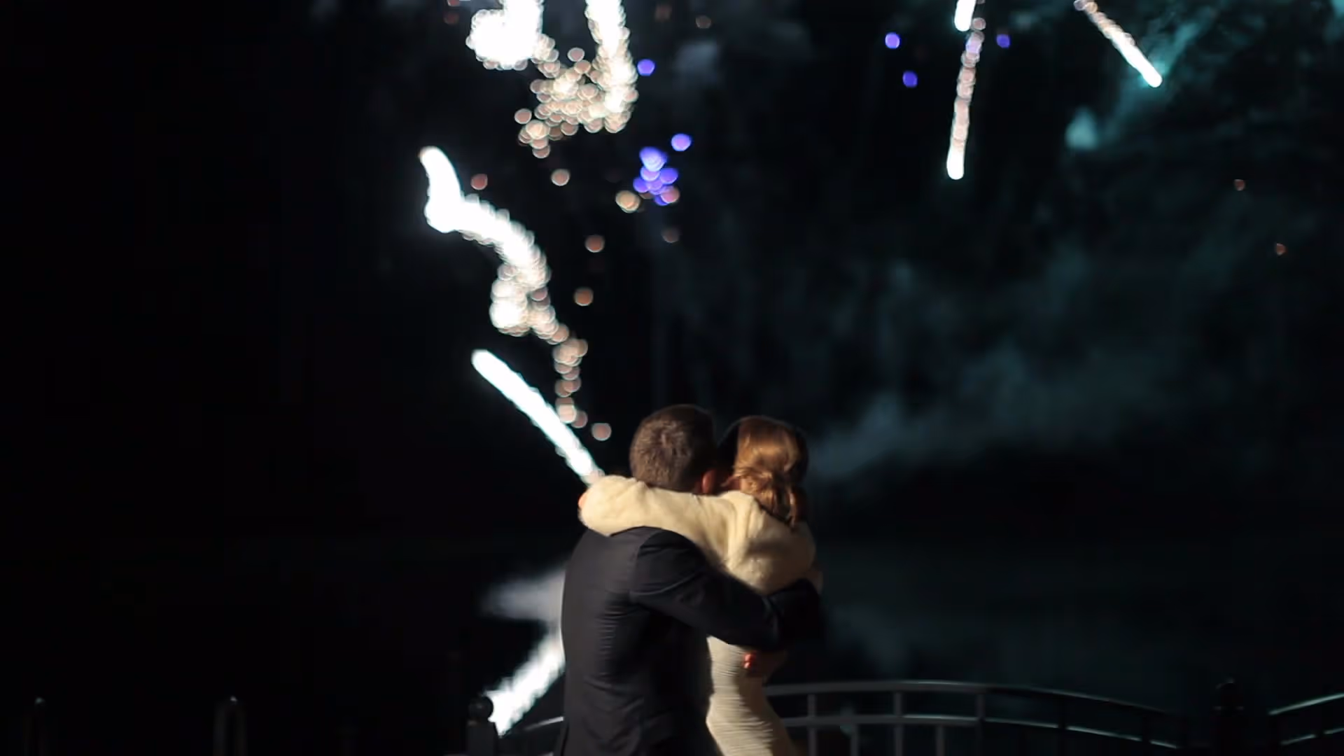 Couple embracing while watching fireworks at their wedding on the French Riviera
