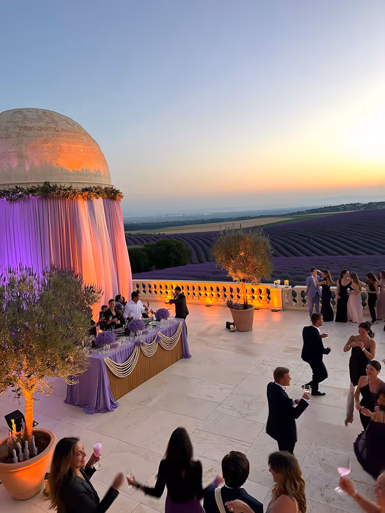 Réception en terrasse éclairée à la lavande lors d'un mariage en Provence