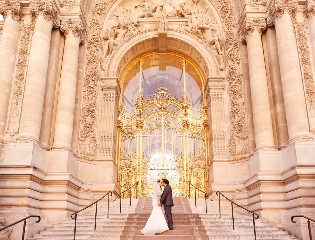 Mariés sur les marches du Petit Palais devant un portail doré parisien