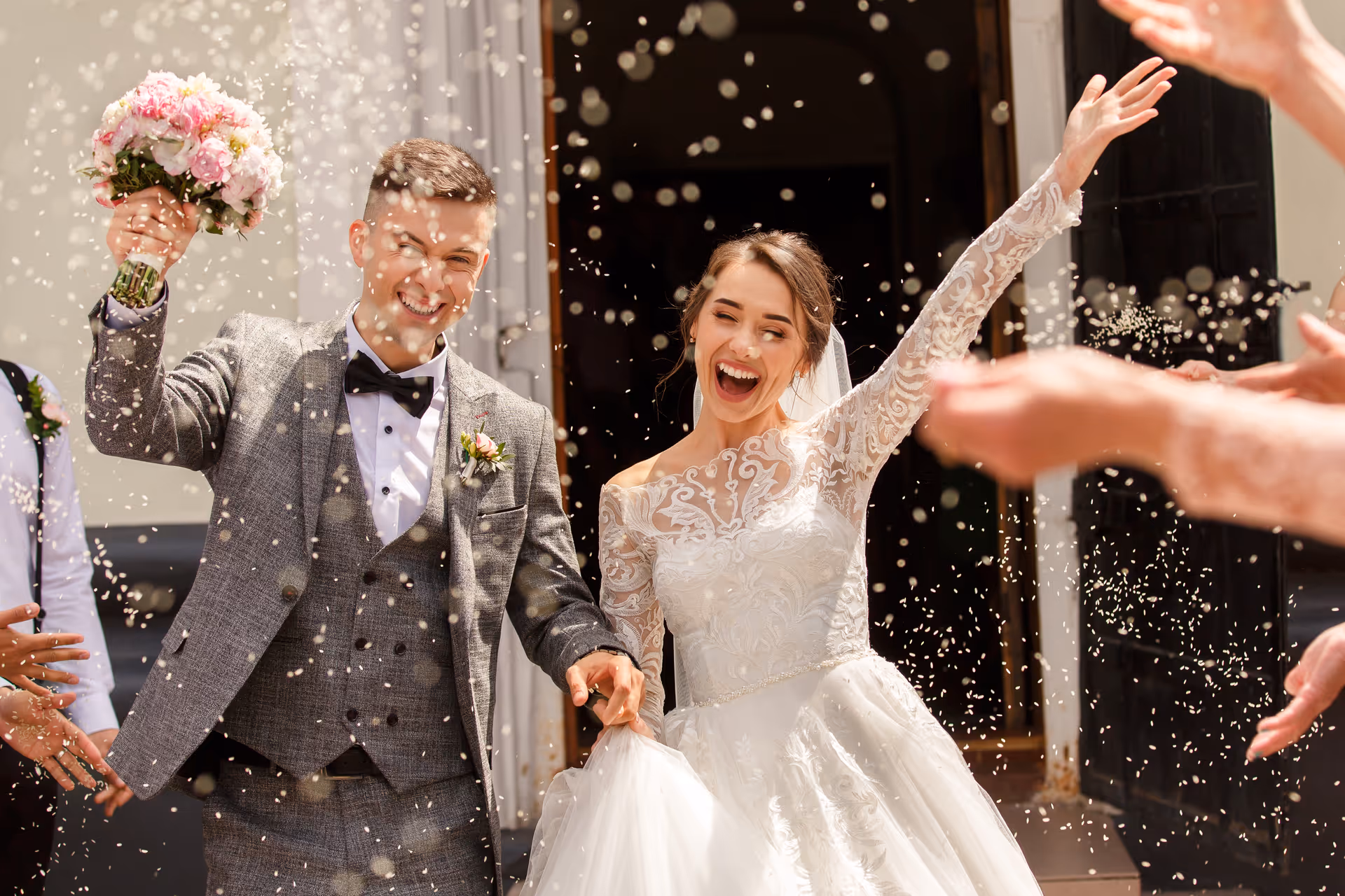 Newlywed couple showered with confetti as they leave their ceremony