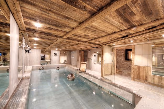 Indoor pool and spa in a luxury alpine chalet, reclaimed wood ceiling, Megève