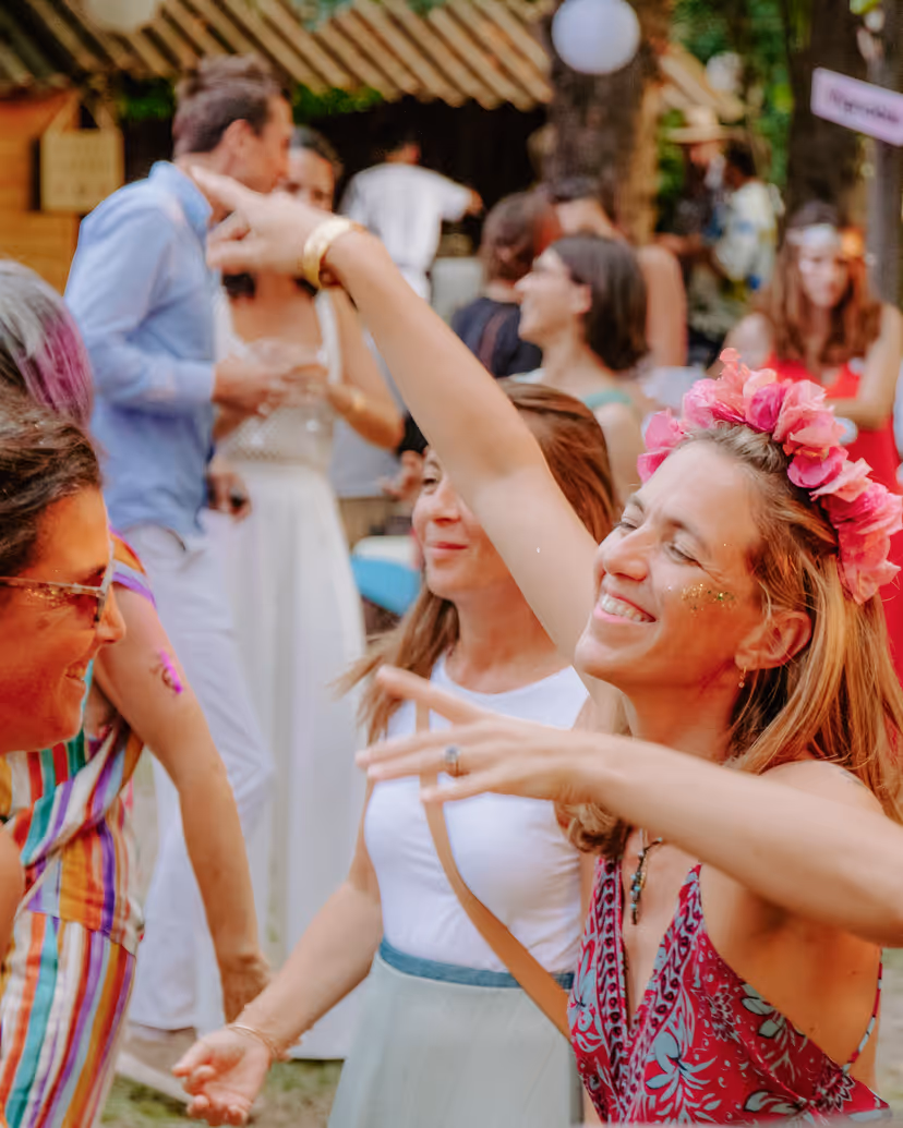 Guests dancing with flower crowns and glitter at a festival wedding brunch in Provence