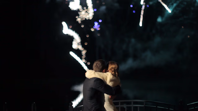Couple enlacé regardant le feu d'artifice de leur mariage sur la Côte d'Azur